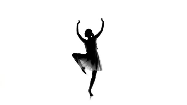 Slim girl with ponytail starts dance modern contemporary style on white, silhouette, slow motion — Stock videók