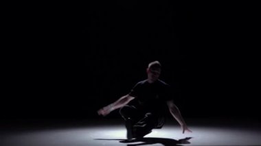 Koyu renk takım elbiseli dansçı breakdance dans başlar, siyah, gölge, yavaş hareket