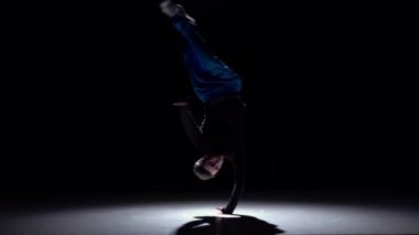Modern breakdance adam atlama siyah, gölge, yavaş hareket üzerinde dans başlar