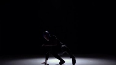 Yakışıklı breakdance tarzı dansçı dans devam ediyor, siyah, gölge, yavaş hareket