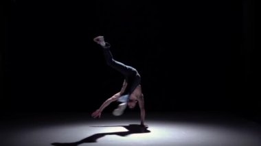 Siyah, gölge, yavaş çekimde el duruşu yapan şapkalı breakdancer adam