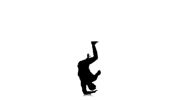 Dancer jumps and stands on hands dancing breakdance, makes movement, white, silhouette, slow motion — Stockvideo