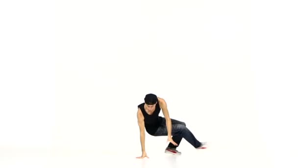 Jeune homme en costume noir se tient sur les mains dansant breakdance, blanc, ralenti — Video