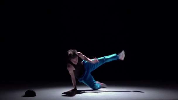 Ballerino in pantaloni blu danza breakdance sulle mani, nero, ombra, slow motion — Video Stock