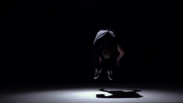 Stílusos és hűvös Breakdance stílusú táncos ugrik át a fejét, a fekete, árnyék, lassított — Stock videók