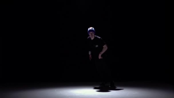 Knappe breakdance stijl danser begint dansen, op zwart, schaduw, Slow Motion — Stockvideo