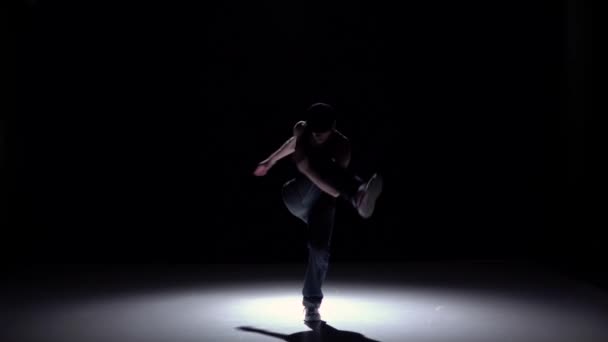 Talanted dancer man starts dancing breakdance on black, shadow, slow motion — Stock video