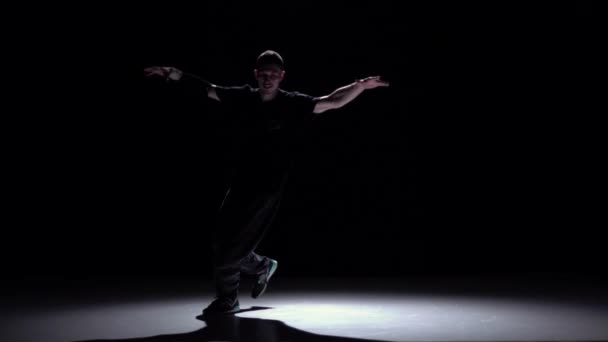 Stylish breakdance style dancer starts dance, on black, shadow, slow motion — Stock Video