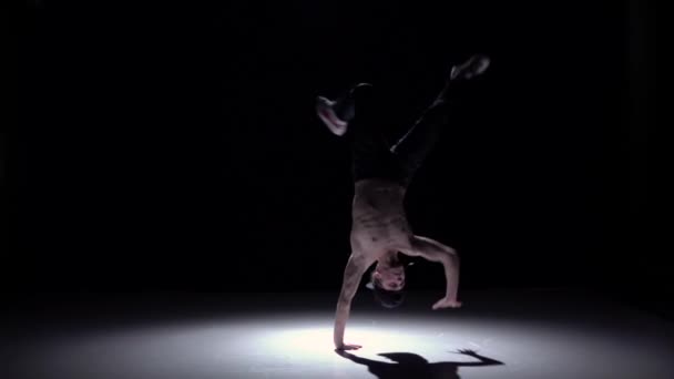 Dancer man with naked and denim torso starts dancing breakdance on black, shadow, slow motion — Stock Video