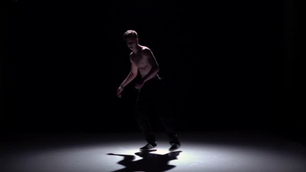 Blonde breakdancer man doet handstand en dans breakdance op zwart, schaduw, slow-motion — Stockvideo