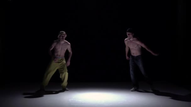Dos bailarines con talentos que actúan y continúan bailando breakdance en negro, sombra, cámara lenta — Vídeo de stock