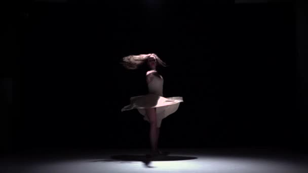 Moderne danseres meisje in witte begint dansen hedendaagse, wervelingen op zwart, schaduw, slow-motion — Stockvideo