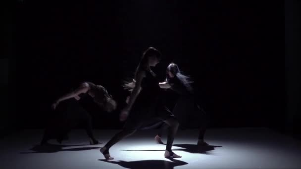 Début gracieuse danse contemporaine de trois danseurs sur noir, ombre, ralenti — Video