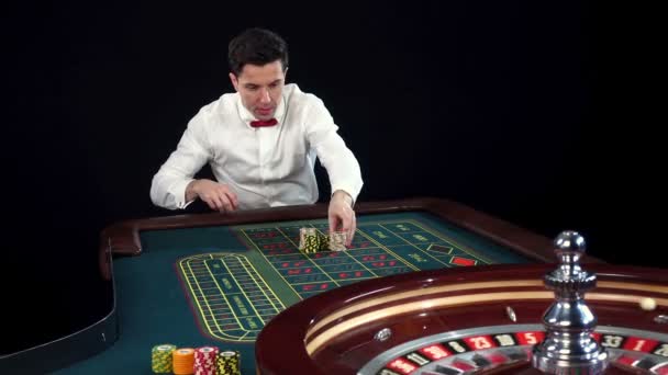 Muž hrající ruletu vyhrává v kasinu. Černé