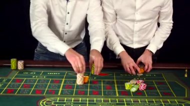 Young cute guys dressed formally playing roulette. Black