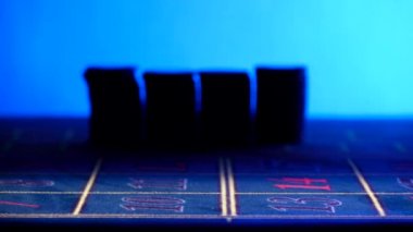 Hands bet chips, one fall down on roulette table, shadow