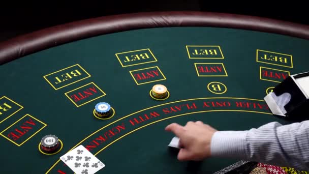 Croupier distribuisce carte sul tavolo verde con chip al casinò — Video Stock