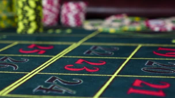 Un chip di gioco d'azzardo arancione che cade sul tavolo della roulette, al rallentatore — Video Stock