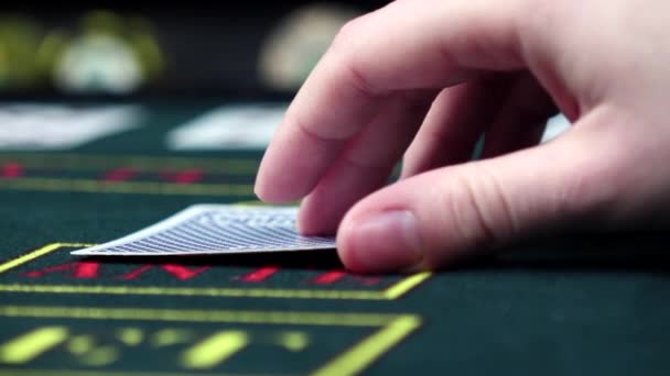 Игрок проверяет свои карты играя в покер, крупным планом, замедленной съемки — стоковое видео