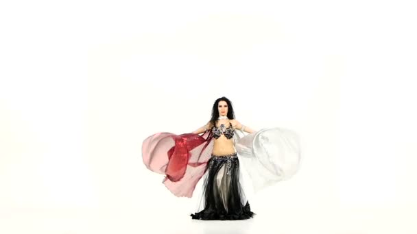 Bela jovem dançarina de barriga exótica com duas asas e balançando os quadris, em movimento branco e lento — Vídeo de Stock