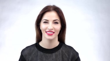 Young girl playful winking brunette woman with brown hairstyle showing trendy makeup. Slow motion