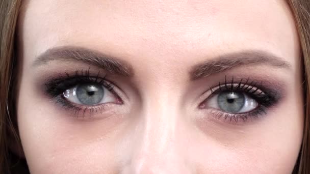 Hermosos ojos azules, parpadeo, maquillaje brillante. De cerca. — Vídeo de stock