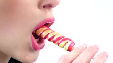 Seksi kız bir lolipop yalama. Beyaz. Yakından kapatın. Yavaş çekim