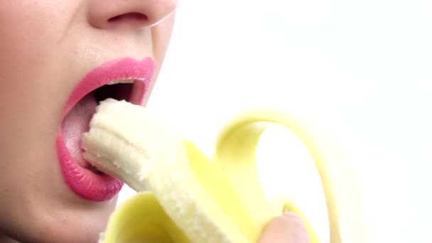 Mulher sexy com lábios cor de rosa comendo banana. Fecha. Movimento lento — Vídeo de Stock