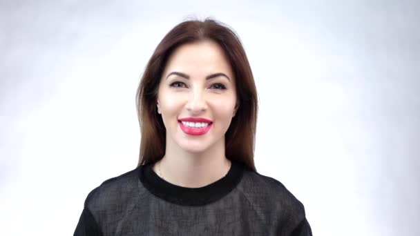 Όμορφη νεαρή γυναίκα που δείχνει το χαμόγελό της ή τα λευκά της δόντια, απομονωμένα σε λευκό φόντο. Αργή κίνηση — Αρχείο Βίντεο