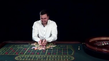 Kumarhanede kumar fişi atan bir adam. Siyah. Yavaş çekim