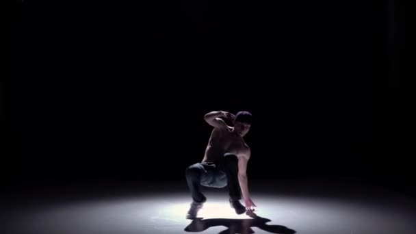 Breakdance man dancing from sitting position breakdance on black, shadow, slow motion — Stock Video