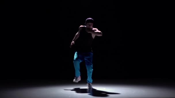 Bailarina en pantalones azules comienza a bailar breakdance, en negro, sombra, cámara lenta — Vídeo de stock