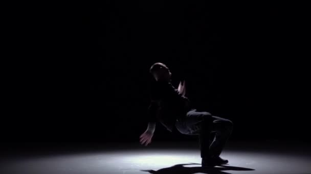 Класна танцівниця в стилі breakdance продовжує танцювати, на чорному, тіні, повільному русі — стокове відео