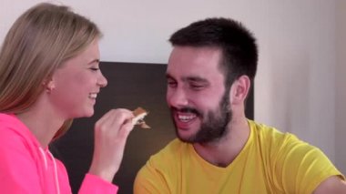 Woman feeding her boyfriend girl feeds from hands, closeup