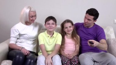mutlu bir aile birlikte kanepede televizyon izlerken