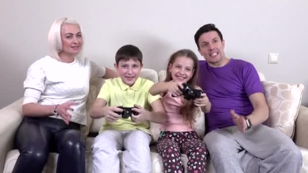 Позитивная семья играет вместе в видеоигры в гостиной — стоковое видео
