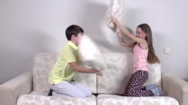 Mutlu gülen erkek ve kız kardeş bir yastık mücadele sahip