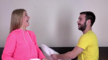 Yatak odasında yastık kavgası olan seksi genç çift, slowmotion