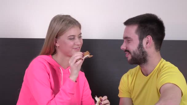 Homem e mulher felizes tomando café da manhã na cama juntos, close-up — Vídeo de Stock