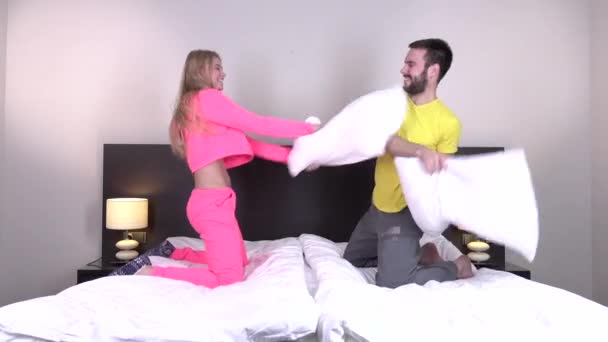 Portret van sexy jonge paar met kussen vechten in slaapkamer — Stockvideo