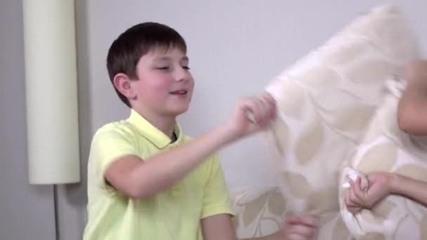 집에서 소파에서 베개 싸움을하는 행복한 웃음 형제와 자매 — 비디오
