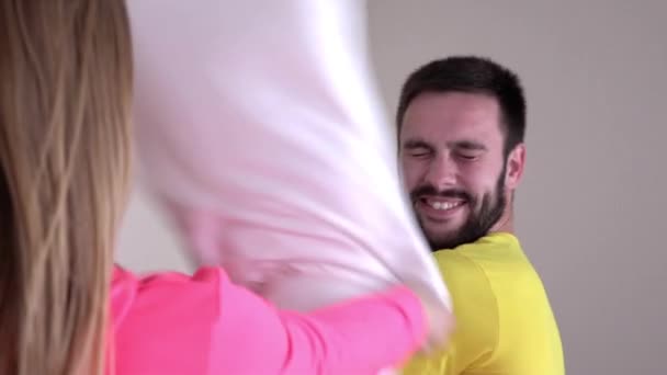 Young couple in bright pajamas, pillow fight, slowmotion — Stockvideo