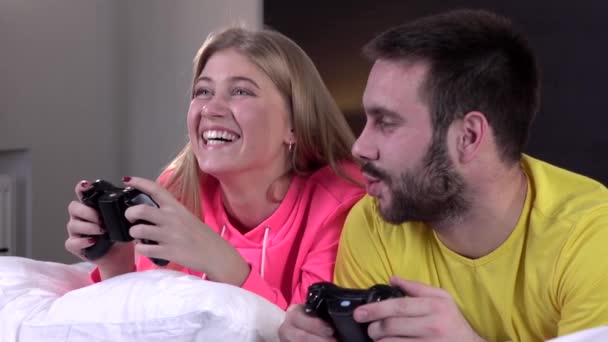 Pareja joven en pijama jugando videojuegos juntos, slow motion, primer plano — Vídeos de Stock