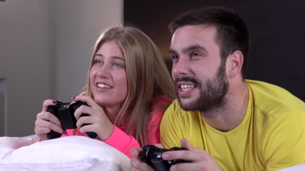 Casal jogando videogames na cama, câmera lenta, close-up — Vídeo de Stock