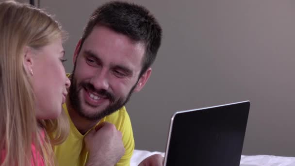 Homem bonito mostrando algo na tela do laptop para sua menina, câmera lenta — Vídeo de Stock