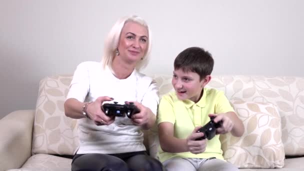 Мальчик с мамой играют в видеоигры дома, замедление — стоковое видео