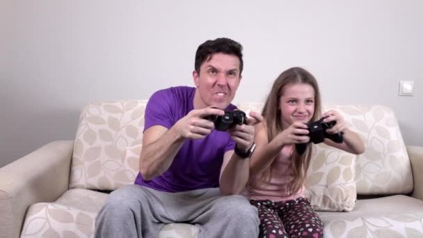 Far och dotter spelar datorspel hemma, slowmotion — Stockvideo