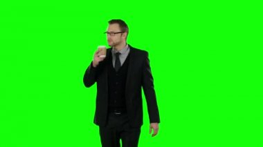 Yürüyüş ve kahve içme iş adamı. Yeşil ekran.