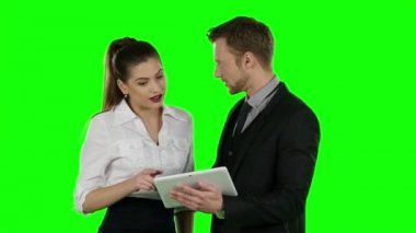 İki memur birlikte bir dizüstü bilgisayar bak. Online alışveriş, yeşil ekran
