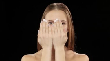 Modeli yüzünü elleri kapsar ve sonra ayraçlar gülümsemesiyle gösterir. Siyah